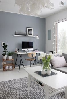 a living room filled with furniture and a white coffee table in front of a window