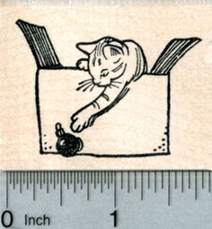 a rubber stamp with a cat in a box on it's side and a measuring ruler