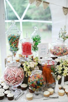 a table topped with lots of candy and cupcakes