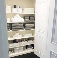 an organized closet with white shelving and baskets