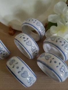 five blue and white ceramic knobs with hearts on them next to a bouquet of flowers