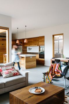 a living room filled with furniture next to a kitchen