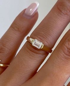 a woman's hand with a ring on it and a baguette in the middle