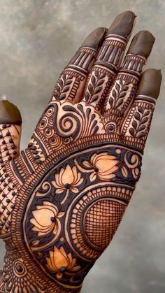 a woman's hand with henna tattoos on it