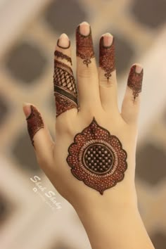 a woman's hand with henna tattoos on it