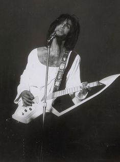 a black and white photo of a man playing an electric guitar