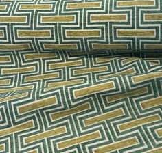 a green and white fabric with gold lines on the side, in an abstract pattern