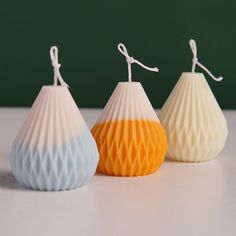 three small white and yellow vases sitting next to each other