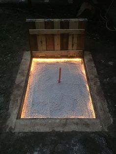 an open wooden box sitting on top of snow covered ground with lights in the middle