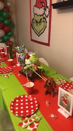 the table is set up with red and green paper plates, napkins, and decorations