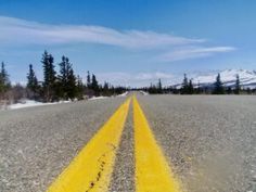 an empty road with yellow painted lines on it