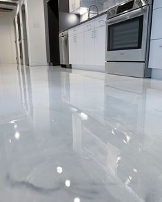 a kitchen with white marble floors and stainless steel stove top oven in the center area