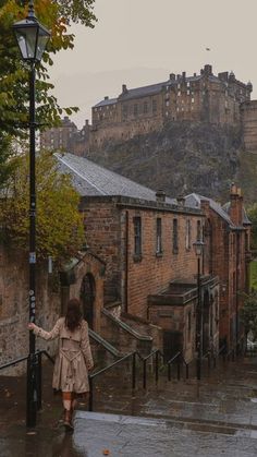 a woman is walking down the street in the rain