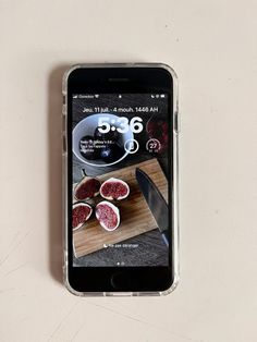 a cell phone sitting on top of a table next to a cutting board and knife