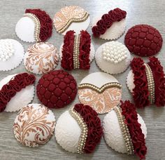 many decorated cookies are arranged on a table with white and red icing around them