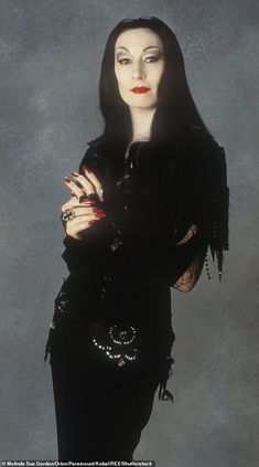 an image of a woman in black dress with her arms crossed and hands folded over her chest