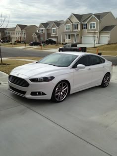 a white car is parked on the street