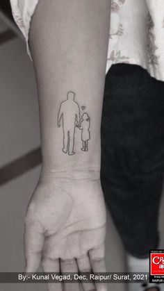 a woman's arm with a small tattoo of a man and child on it