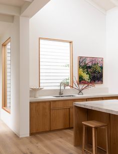 a kitchen with wooden cabinets and an island in the middle is seen from across the room