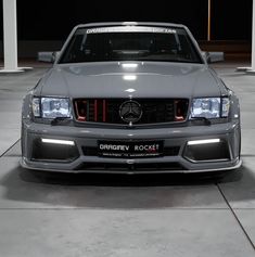 the front end of a silver car parked in a garage