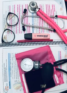 an assortment of medical supplies on top of a paper with glasses and a stethoscope