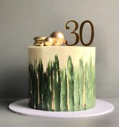 a green and white cake with the number 30 on top is decorated with gold ornaments