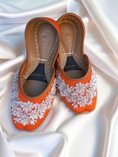 Embrace the whimsy and elegance of our Sunset Brilliance flat shoes, featuring a vibrant orange base adorned with beads, sequins, and intricate wire embellishments in enchanting floral patterns. Whether you call them Punjabi jutti, mojari for women, or women's khussa, these jeweled flats blend timeless allure with a touch of modern flair, making them the perfect choice to elevate any special occasion. Product Details: Base Material: Luxurious orange fabric Embellishments: Beads, sequins, and sil Flat Wedding Shoes With Rhinestones, Crystal Embellished Flats For Wedding, Elegant Flats For Reception, Elegant Festive Flats With Round Toe, Embellished Round Toe Wedding Shoes, Embellished Flat Heel Wedding Shoes For Reception, Embellished Flats For Wedding, Elegant Closed Toe Flats For Festivals, Formal Closed Toe Flats For Festivals