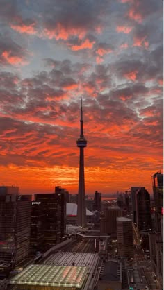 the sky is red and orange as the sun sets over some buildings in this city