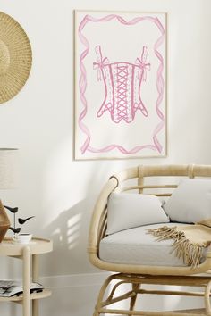 a room with a wicker chair and pink artwork