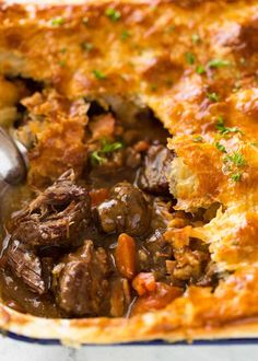 a close up of a casserole with meat and vegetables