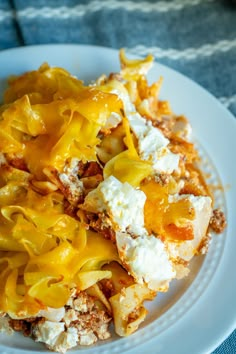 a white plate topped with macaroni and cheese on top of a blue table cloth