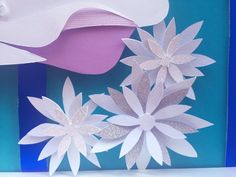 some paper flowers on a blue and white background