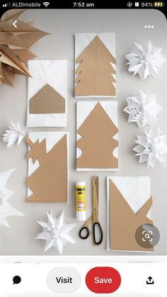 some paper snowflakes and scissors sitting on top of a white table with brown paper