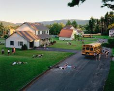 a school bus parked on the side of a road next to a lush green field