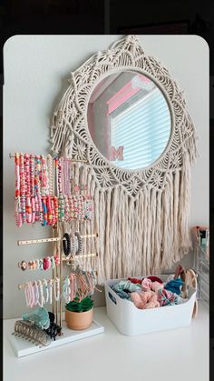 a white table topped with lots of bracelets and jewelry next to a round mirror