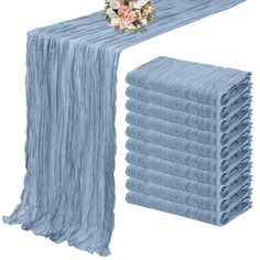 a stack of blue cloths with flowers on top and one folded in the middle