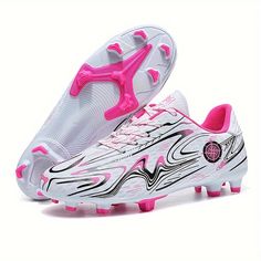 a pair of white and pink soccer shoes on a white background with the bottom part of the shoe visible