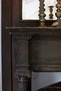 an old fireplace with candles and a mirror in the backround, on display