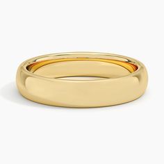 a yellow gold wedding ring on a white background