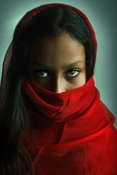 a woman wearing a red scarf around her head and looking at the camera with blue eyes