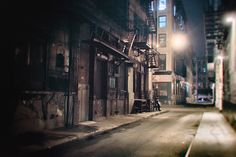 an empty city street at night with no one on the sidewalk or people walking down it