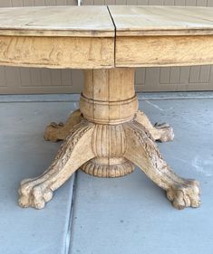 an old wooden table sitting on top of a cement floor