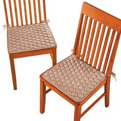 two wooden chairs sitting side by side with one chair up and the other in front