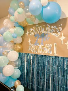 balloons and streamers are hanging from the ceiling in front of a sign that reads carolina's 21st birthday