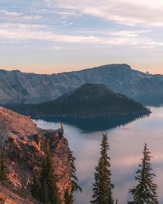 a person standing on top of a mountain overlooking a lake