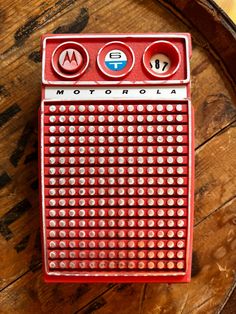 a red radio sitting on top of a wooden table