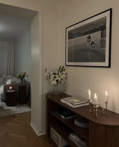 a living room filled with furniture next to a bed and a table topped with candles