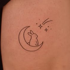 a small rabbit sitting on the moon with stars in it's back tattoo design