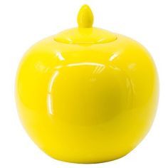 a yellow ceramic apple shaped container with a lid on the front and side, set against a white background