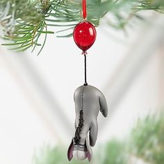 a black and white skeleton ornament hanging from a pine tree